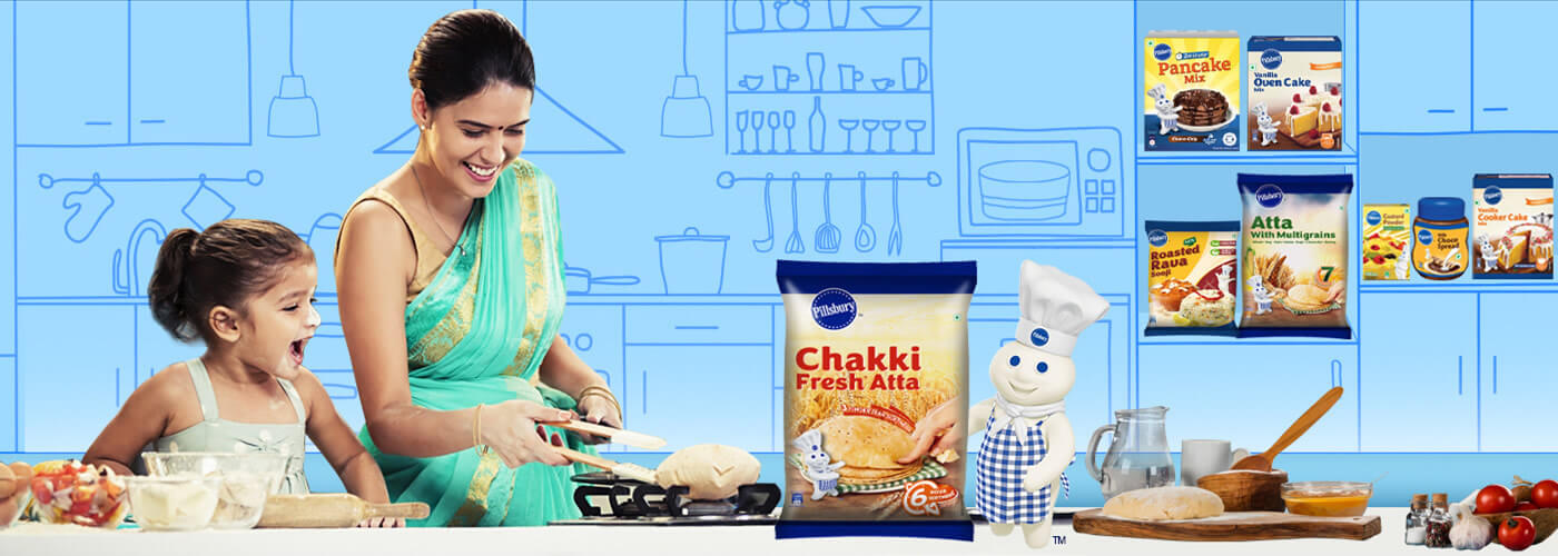Woman and young child cooking in a kitchen with a small doughboy in the corner and a Chakki Fresh Atta packshot