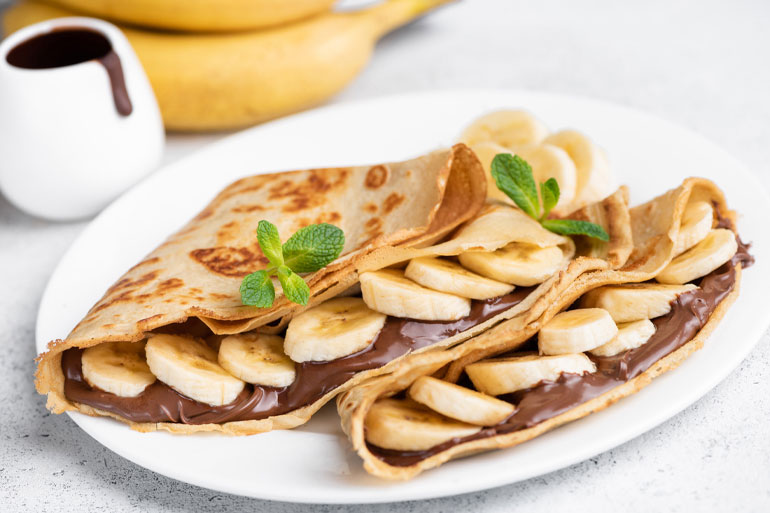Crepe on a plate with sliced bananas lifestyle image