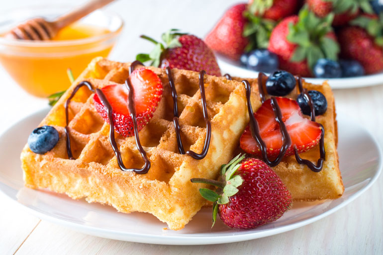 Waffles on a plate with blueberries and strawberries